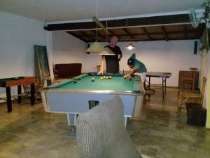 dois homens a jogar bilhar numa sala com uma mesa de bilhar em Cimajasquare Hotel & Restaurant em Pelabuhanratu