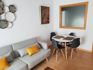 Apartamentos Soho Boutique Plaza Mayor Caceres في قصرش: غرفة معيشة مع أريكة وطاولة