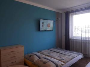 コウォブジェクにあるDom Gościnny Kotwicaの青い壁のベッドルーム(ベッド1台、窓付)