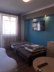 コウォブジェクにあるDom Gościnny Kotwicaのベッド2台、壁掛けテレビが備わる客室です。