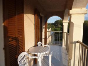 a balcony with two chairs and a table on a porch at Apartamentos Villa Primera in Cala Figuera