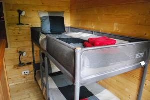 The Cabin with heated outdoor pool في Chalandrey: سرير بطابقين في غرفة مع جدران خشبية