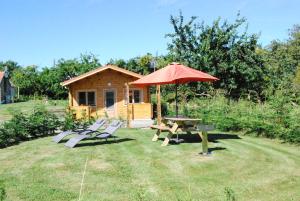 un tavolo da picnic e un ombrellone di fronte a una cabina di The Cabin with heated outdoor pool a Chalandrey
