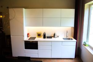 a small kitchen with white cabinets and a sink at B&B Koetshuis in Bruges