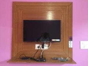 a tv in a wooden frame with alevision at CHÉRI HOME Stay in Khajurāho