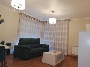 a living room with a couch and a table at Pedrouzo Suites in O Pedrouzo