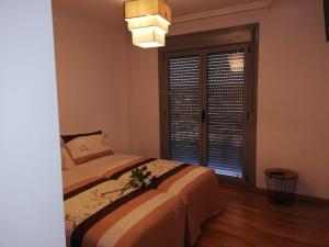 a bedroom with two beds and a window at Pedrouzo Suites in O Pedrouzo