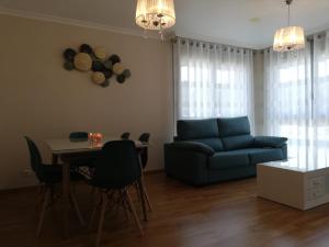 sala de estar con sofá azul y mesa en Pedrouzo Suites, en O Pedrouzo