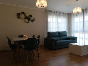 a living room with a blue couch and a table at Pedrouzo Suites in O Pedrouzo +9 photos