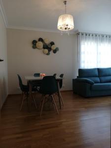 a living room with a table and a blue couch at Pedrouzo Suites in O Pedrouzo