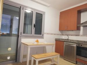 a kitchen with a table and a counter in it at Pedrouzo Suites in O Pedrouzo