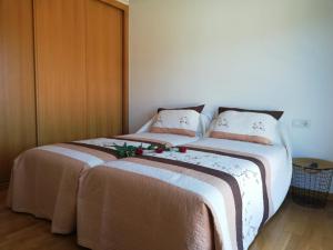 two beds sitting next to each other in a bedroom at Pedrouzo Suites in O Pedrouzo