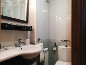 a bathroom with a sink and a toilet at Pedrouzo Suites in O Pedrouzo