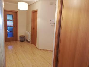 an empty room with a hallway with a door at Pedrouzo Suites in O Pedrouzo