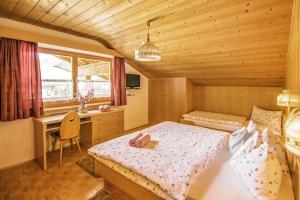 1 dormitorio con cama y escritorio en Cesa Sara, en Ortisei