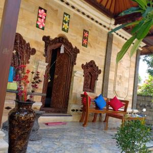a room with two chairs and a table and a vase at Kuwera Homestay in Nusa Penida