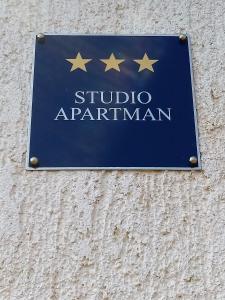 una señal en el lado de un edificio con estrellas en él en Studio apartment Meli, en Ogulin