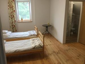 a bedroom with two beds and a window and a table at Nocleg na Mazurach in Stacze