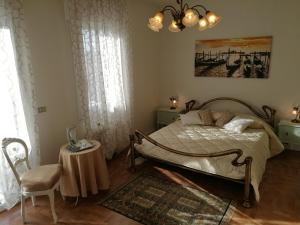 a bedroom with a bed and a chair and a table at Ca' Nadia in Campalto