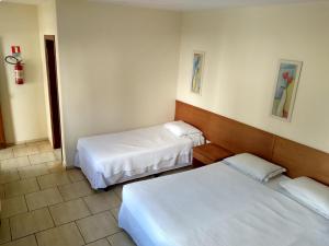 En eller flere senger på et rom på Hotel Lago das Pedras