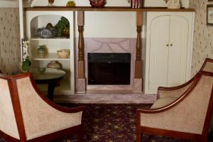 a living room with two chairs and a fireplace at Victoria's Historic Inn in Wolfville