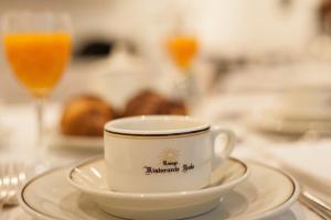 eine Tasse auf einem Teller auf einem Tisch mit einem Glas Orangensaft. in der Unterkunft Albergo Sole in Mariano Comense