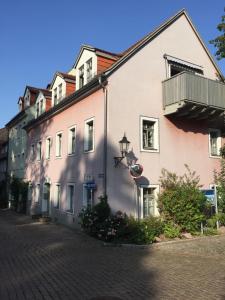 a white building with a balcony on a street at Stadthaus Rosengasse in Meißen