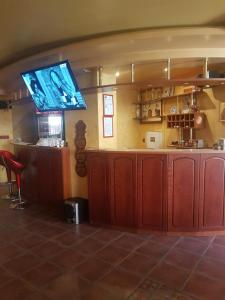 a bar with a flat screen tv on the wall at Family Hotel Silvestar in Veliko Tŭrnovo