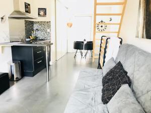 a living room with a couch and a kitchen at CosyStudio2 Site du Futuroscope in Jaunay-Marigny