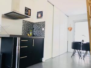 a kitchen with black cabinets and a black counter top at CosyStudio2 Site du Futuroscope in Jaunay-Marigny