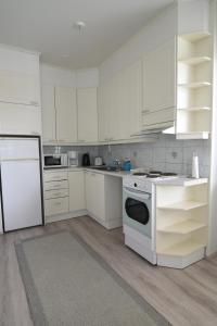 a kitchen with white cabinets and a white stove top oven at Gasthaus Kantolankulma in Lappeenranta +38 photos