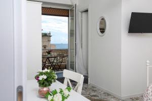 a room with a table and a view of the lighthouse at Maison Ortigia in Syracuse