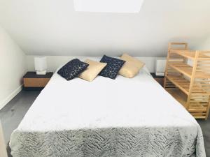 a bedroom with a white bed with pillows on it at CosyStudio2 Site du Futuroscope in Jaunay-Marigny