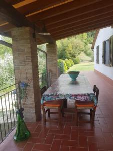 patio ze stołem i krzesłami na ganku w obiekcie Camere Montalbano w mieście San Miniato +24 zdjęcia