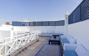 Un balcón con muebles azules y blancos y el océano. en La Casa Del Mar, en Essaouira