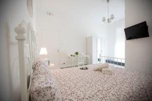 a bedroom with a white bed and white walls at Maison Ortigia in Syracuse