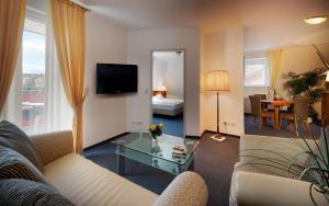 ein Wohnzimmer mit einem Sofa und einem Tisch in der Unterkunft Hotel Sonneneck in Bad Kissingen