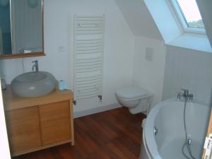 ein weißes Bad mit einem Waschbecken und einem WC in der Unterkunft Ti Post in Groix