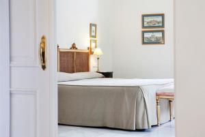 ヘレス・デ・ラ・フロンテーラにあるヴィラ ヘレスの白い部屋のベッドルーム1室(ベッド1台付)