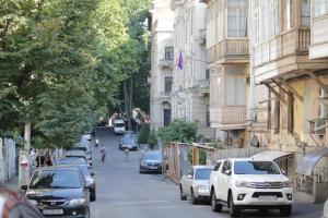 una calle de la ciudad con coches estacionados al costado de la carretera en Downtown-home in the heart of old Tbilisi, en Tiflis