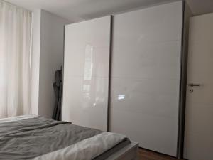 a bedroom with a large glass closet with a bed at 2-Zimmer-Apartment Ratingen Ost in Ratingen