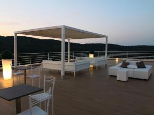 a deck with couches and tables on a roof at Hotel Le Ginestre Family & Wellness in Vieste