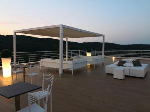 een terras met banken en tafels op een dak bij Hotel Le Ginestre Family & Wellness in Vieste