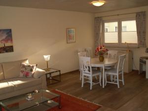 a living room with a couch and a table and chairs at Sylt in Leck