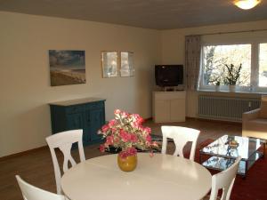 sala de estar con mesa blanca y sillas en Sylt, en Leck