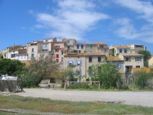 a group of buildings in front of a field at Maison de la Fontaine in Embres-et-Castelmaure