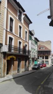 un bâtiment sur le côté d'une rue avec des voitures garées dans l'établissement Hotel Areces, à Grado