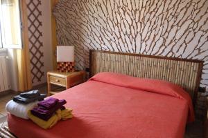 um quarto com uma cama vermelha e um cobertor vermelho em B&B S'arenada em Ghilarza