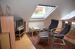 a living room with two chairs and a tv at Ferienwohnung Rudolf-Lindner in Neustadt an der Aisch