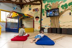 zwei Kinder sitzen auf Sitzsäcken im Spielzimmer in der Unterkunft Zagaia Eco Resort in Bonito